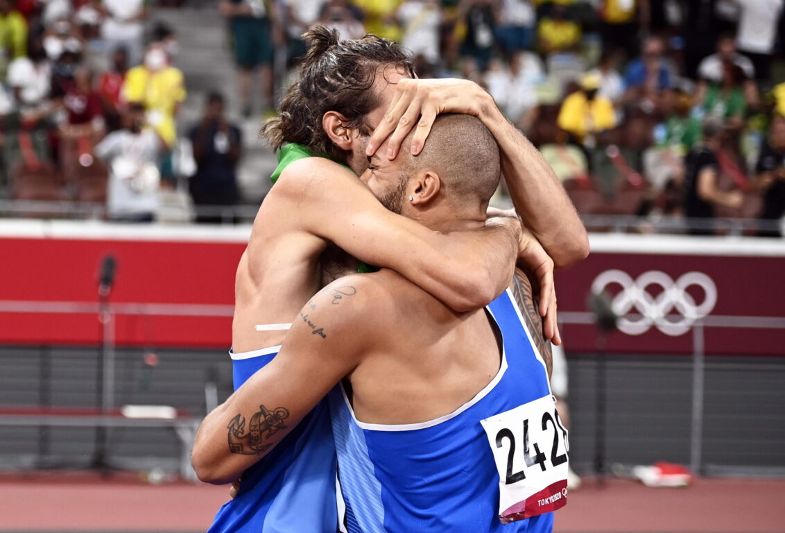 Gianmarco Tamberi abbraccia Marcell Jacobs dopo aver primeggiato rispettivamente nel salto in alto e nei 100 metri. EPA/CHRISTIAN BRUNA